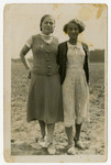 Portrait of sisters, Feiga and Rozka Grosman standing in an open field.