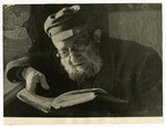 Shmuel Dawid Grosman reads a book [probably in the Lodz ghetto].
