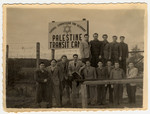 Jewish men pose by the sign at the Palestine Transit Camp prior to their leaving Germany for Palestine.