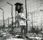 Sara Szajfman stands next to the barbed wire fence surrounding the detention camp in Cyprus.