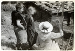 A woman paints a landscape while two young children look on.