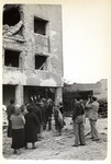 Polish citizens observe a destroyed building in besieged Warsaw while Julien Bryan films the scene.