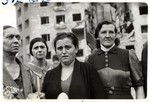 A group of Polish women stare ahead in front of a bombed out building in besieged Warsaw.
