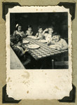 Children at the Nos Petits children's home in Belgium are seated around a table eating.