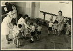 Staff of the Nos Petits kindergarten dance with the children.