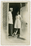 Benjamin Straus and his daughter Betty stand at the entrance of their house.