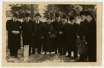 Mourners stand by the grave of Freida Albin.

Pictured are Papa, Aron, Zilla, Harri, Abraham, Opapa, an aquaintance, and a nurse.
