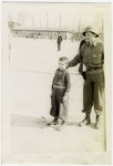 Young survivor of Buchenwald poses with a soldier.