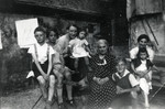 Members of an extended family pose outside a building on a farm.