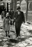 Reine Behar walks down a commercial street in Sofia holding her father's hand.