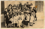 Group portrait of Jewish children and staff, some of whom are in Purim costume, in an orphanage in Athens.