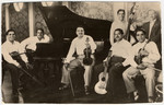 Members of a French-Hungarian Romani musical band pose for a photograph with their instruments.