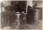View of two large vats in the interior of an unknown building in th Hanover-Ahlem concentration camp.