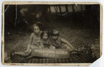 Three little girls sit on a blanket during a vacation in Wisniowa-Gora.