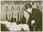Japanese Foreign Minister, Mamoru Shigemitsu, signs the surrender documents on behalf of his government.