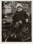 One-year-old Max Beer poses on top of a motorcycle in the Pocking displaced persons' camp.