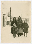 Three generations of women stand in the snow in the Bochnia ghetto.