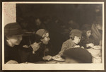 Women and children eat in the dining room of the Jewish Refugee Aid Committee of Antwerp.