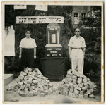 A man and woman stand guard by a memorial to the victims of the Holocaust.