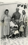The Cassorla family poses near a cabin on a beach.