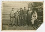Polish Jewish men pose at a lumberyard [probably in prewar Poland] .