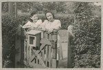 Hanna Bratman and Hanka Bratman Fisch stand by a gate in the Lampertheim displaced persons camp.