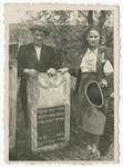 Two family members pose next to the grave of Malka, the daughter of Moshe, a member of the Kodzidlo or Herszlikowicz family.