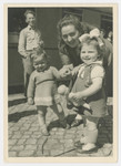 An unidentified woman poses with two toddlers in or near the Bergen-Belsen displaced persons camp.
