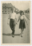 Joe Rosenzweig walks down a street in the Bergen-Belsen displaced persons camp hand in hand with his cousin Anna Rosenzweig