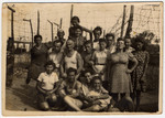 Group portrait of Jewish DPs posing in front of a barbed fence at an internment  camp in Cyprus.