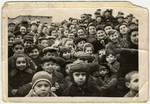 A large group of children and adults crowds together in the Zeilsheim displaced persons' camp.