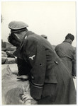 An SS guard [possibly Schmiller] supervises work in the Lipa farm labor camp.