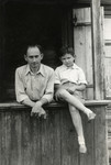 Baruch Rabinovich, and his nephew, Julek Kracowski pose at a window sill.