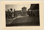 A woman [probably an Austrian civilian] walks past survivors in the Mauthausen concentration camp.