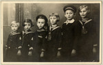 Studio portrait of the Kuttner children, dressed in matching sailor suits.