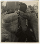 A woman kisses another goodbye next to a fence during Gehsperre action in Lodz ghetto.