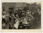 Children in an orphanage in Marysin sit around an outdoor table awaiting the distribution of soup.