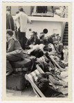 Jewish displaced persons sit on the deck of a ship on the way to the United States.