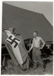 Lloyd Rissinger, a liberator of the Ohrdruf concentration camp, poses next to his tent and and a captured Nazi flag.