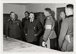 Adolf Hitler meets with several of his key military advisors in the map room of his headquarters.