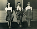Jewish children light a menorah in a community Hanukkah celebration in Manila.