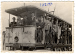 Group portrait of Jewish policemen posing on a streetcar of the Lodz ghetto.