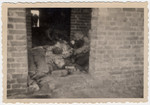 The bodies of prisoners are piled on top of one another in the doorwar of a brick barrack in Woebbelin.