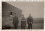Three survivors pose in front a barrack in Woebbelin.
