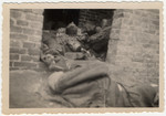 The bodies of prisoners are piled on top of one another in the doorway of a brick barrack in Woebbelin.
