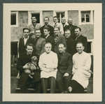 Group portrait of prisoners, one holding a small dog, in the Tittmoning camp.