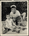 Manny Mandel poses with a younger disabled child and a pair of roller skates he received as a gift from America.