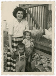Ruth Salamon (nee Weinberger) poses next to a chicken coop with the children of her sister Helena, Moshie and Rochel.