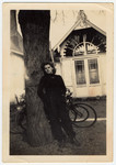 A young woman leans against a tree. 

Pictured is Betty Jacubowicz, who helped to smuggle 52 children to Switzerland.