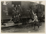 A woman waves farewell to displaced persons leaving Germany on a decorated U.S.